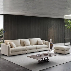 wide l shape fabric sofa with rounded arms, loose back cushions and deep comfortable seating — close view showing the colo...
