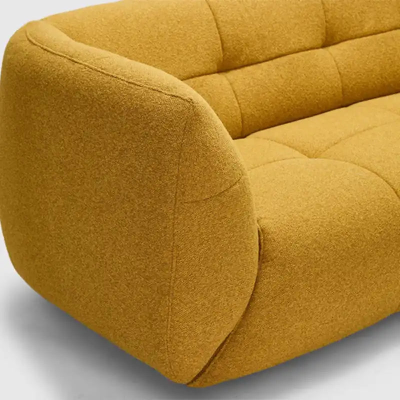 warm mustard rounded sofa with deep square cushioning and a soft textured finish — angled view showing the full shape and...