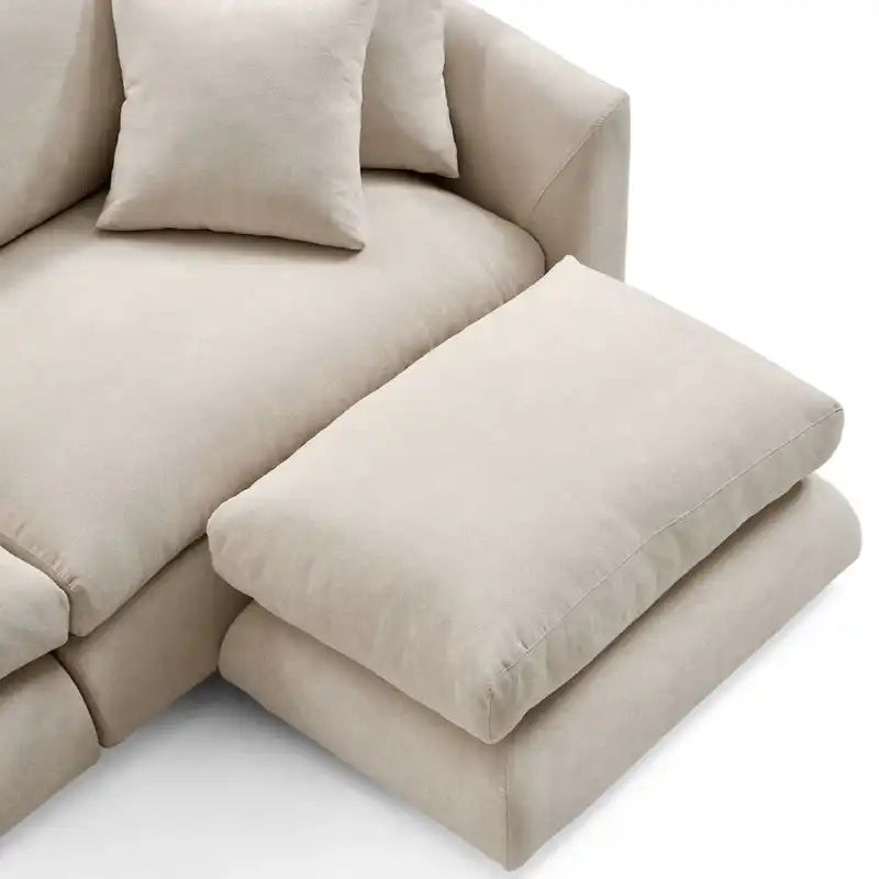 wide l shape fabric sofa with rounded arms, loose back cushions and deep comfortable seating — front view in a bright livi...