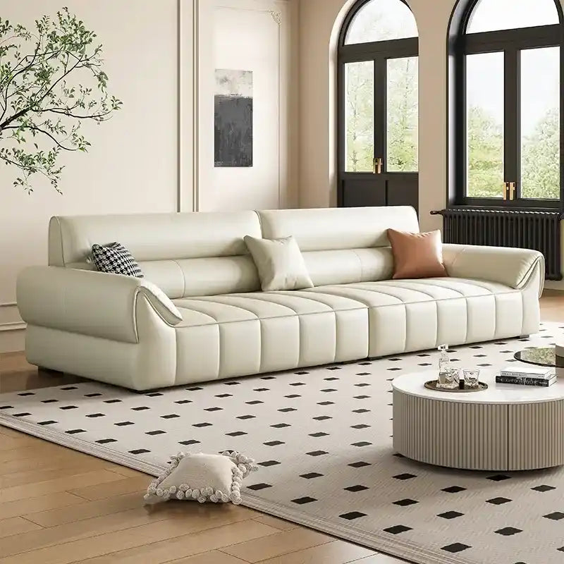 wide leatherette sofa with deep square cushioning and a low relaxed shape — angled view showing the full shape and cushions