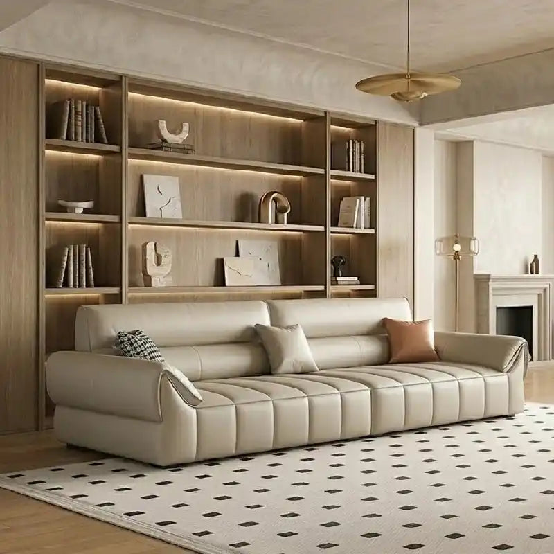 wide leatherette sofa with deep square cushioning and a low relaxed shape — front view in a bright living room