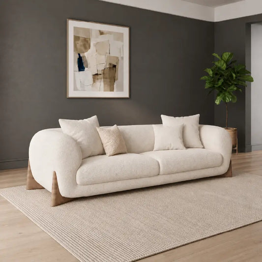 Modern living room with a white sofa, round marble coffee table, and decorative elements.