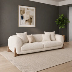 Modern living room with a white sofa, round marble coffee table, and decorative elements.