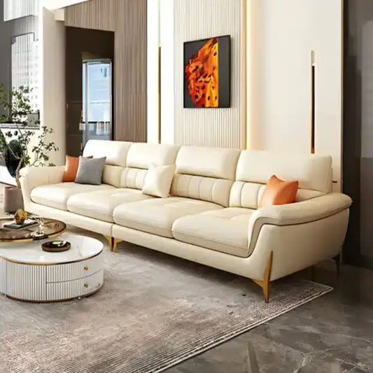 cream high back sofa with vertical cushion panels, rounded arms and slim gold finish legs — front view in a bright living...