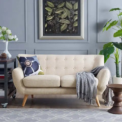 soft beige fabric sofa with rounded arms, buttoned back cushions and slim wooden legs — front view in a bright living room