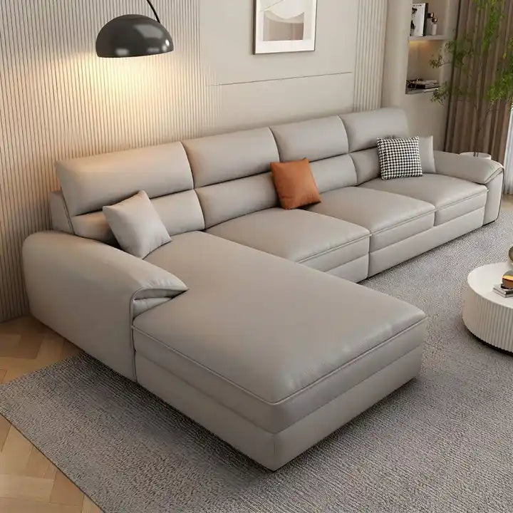 beige l shape leatherette sofa with deep seating, high back cushions and wide padded arms — angled view showing the full s...