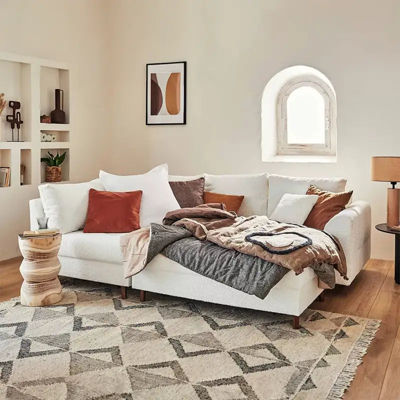 Sleeper sofa with a movable footstool, with a pull-out sleeping area for overnight guests