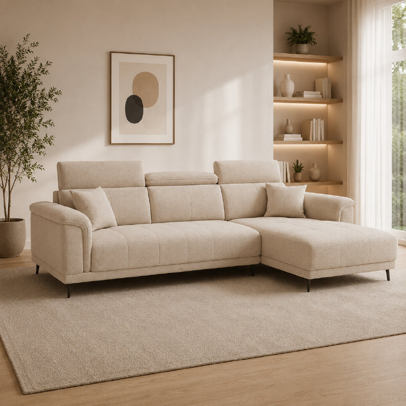 beige l shape sofa with adjustable head support, rounded arms and slim raised legs — side angle showing the arms and raise...