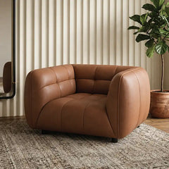 warm brown luxury sofa with deep square cushioning, rounded edges and a low relaxed shape — side angle showing the arms an...