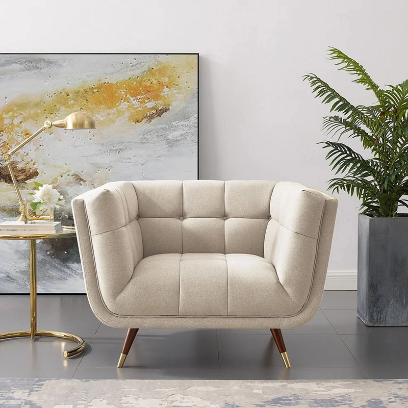 beige fabric sofa with soft curved arms, square cushion details and raised wooden legs — side angle showing the arms and r...