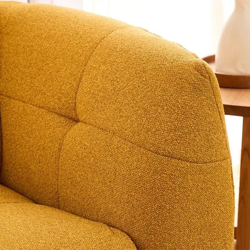 warm mustard rounded sofa with deep square cushioning and a soft textured finish — close view showing the cushion and surf...