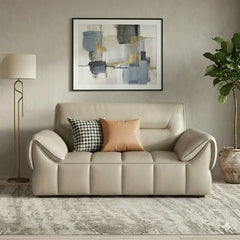 wide leatherette sofa with deep square cushioning and a low relaxed shape — close view showing the cushion and surface det...