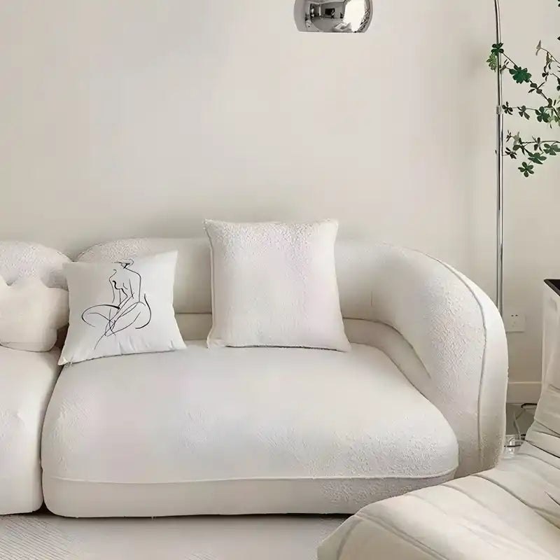 low lounge sofa with thick cushions, loose back pillows and soft rounded edges — close view showing the cushion and surfac...