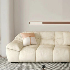 cream l shape sofa with deep soft cushions, rounded arms and a cosy low base — close view showing the cushion and surface...