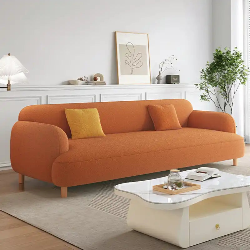 rounded fabric sofa with deep cushions, soft wide arms and a clean modern finish — wide room view showing the complete sea...