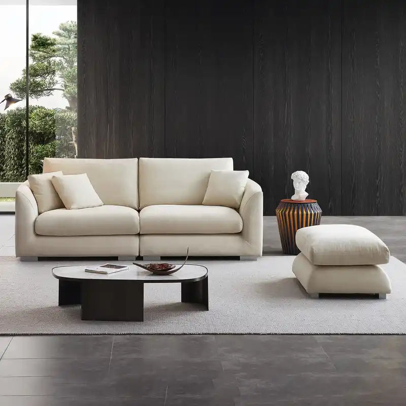 wide l shape fabric sofa with rounded arms, loose back cushions and deep comfortable seating — wide room view showing the...