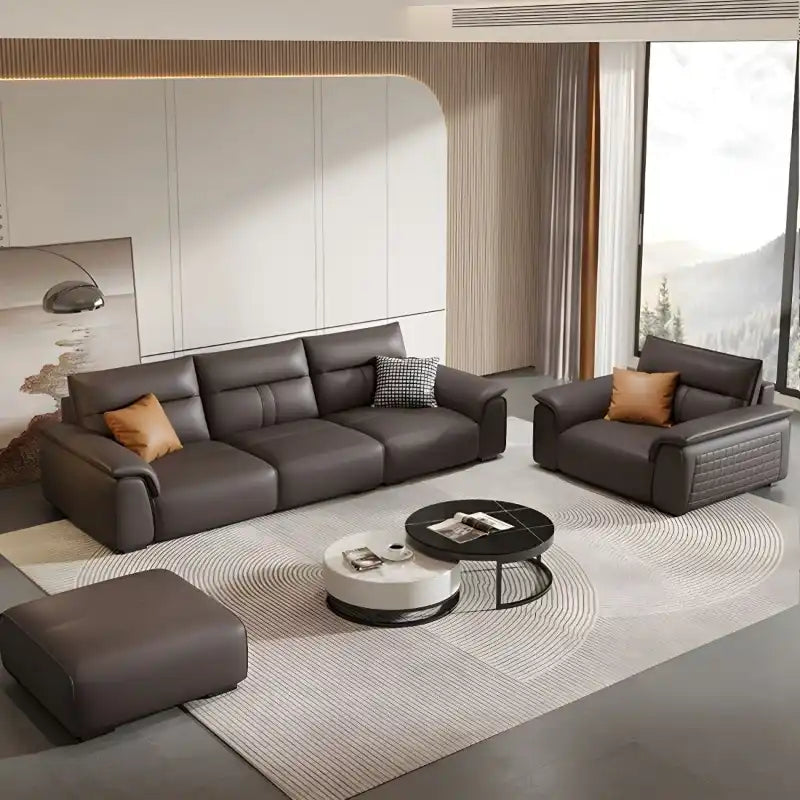 dark brown luxury sofa with broad pillow soft arms, cushioned back and detailed side panels — wide room view showing the c...
