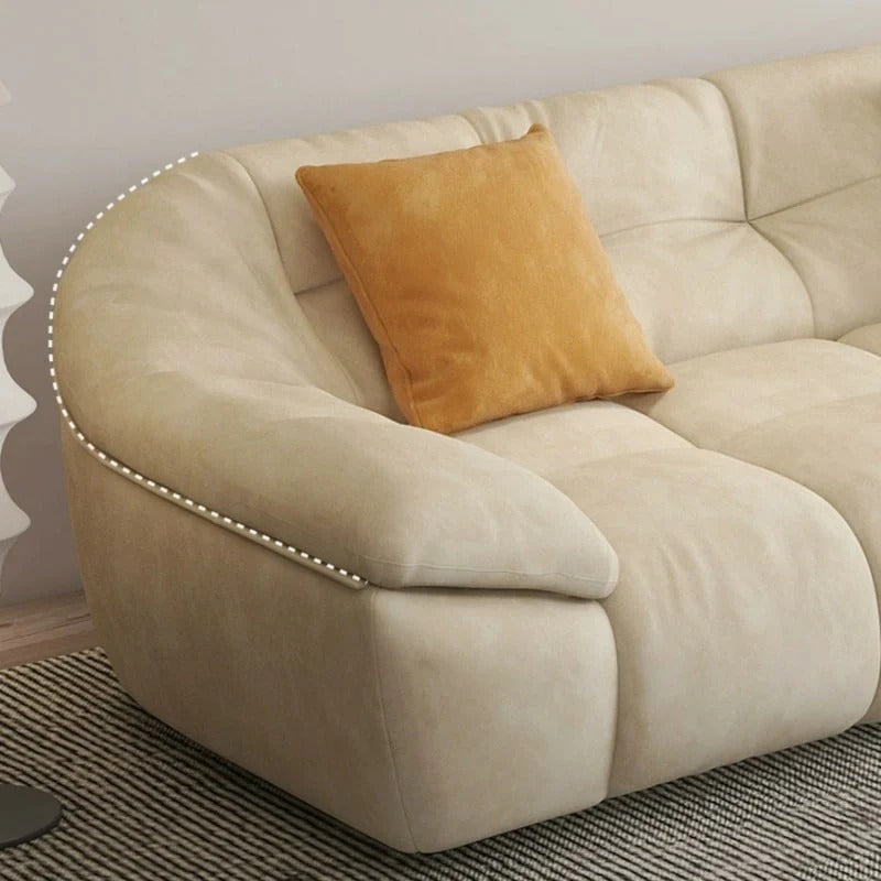 cream l shape sofa with deep soft cushions, rounded arms and a cosy low base — wide room view showing the complete seating...