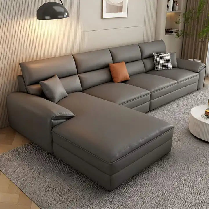 beige l shape leatherette sofa with deep seating, high back cushions and wide padded arms — front angle showing the back s...