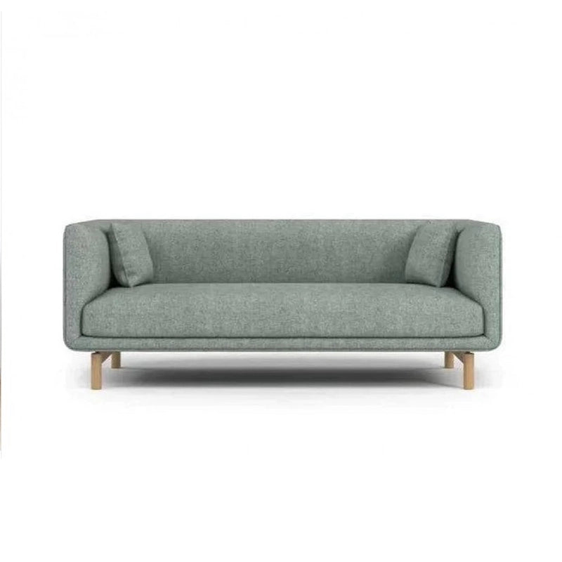 curved fabric sofa with soft wraparound arms, deep cushioning and raised wooden legs — alternate angle showing the full de...