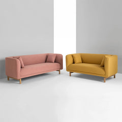 curved fabric sofa with soft wraparound arms, deep cushioning and raised wooden legs — full view with the complete shape c...