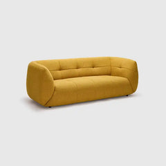 warm mustard rounded sofa with deep square cushioning and a soft textured finish — close view showing the colour and mater...