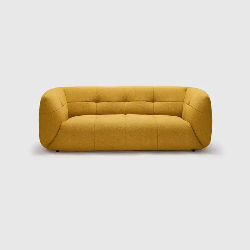 warm mustard rounded sofa with deep square cushioning and a soft textured finish — room setting showing the relaxed seatin...