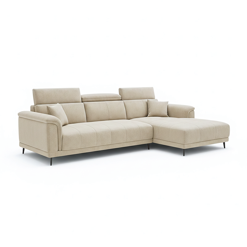 beige l shape sofa with adjustable head support, rounded arms and slim raised legs — room setting showing the relaxed seat...