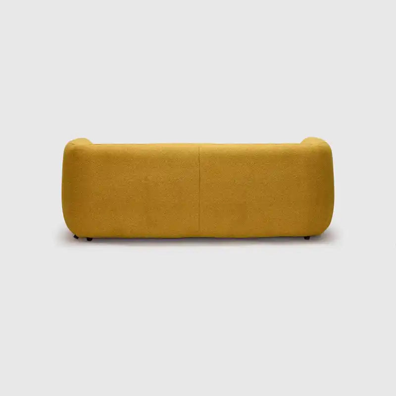 warm mustard rounded sofa with deep square cushioning and a soft textured finish — front view in a bright living room