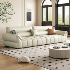 wide leatherette sofa with deep square cushioning and a low relaxed shape — angled view showing the full shape and cushions