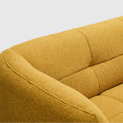 warm mustard rounded sofa with deep square cushioning and a soft textured finish — side angle showing the arms and raised...