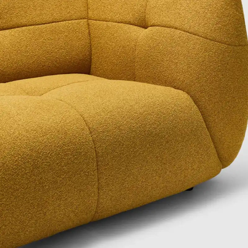 warm mustard rounded sofa with deep square cushioning and a soft textured finish — close view showing the cushion and surf...