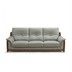 corner sofa with deep cushions, rounded arms and warm polished wooden side details — close view showing the colour and mat...