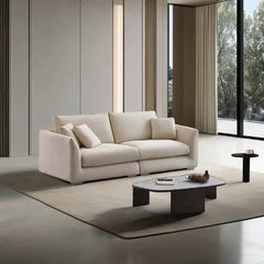 wide l shape fabric sofa with rounded arms, loose back cushions and deep comfortable seating — front view in a bright livi...