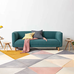 curved fabric sofa with soft wraparound arms, deep cushioning and raised wooden legs — front view in a bright living room
