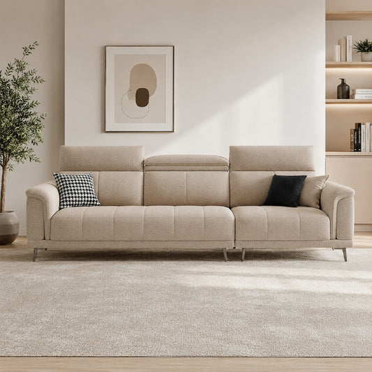 beige l shape sofa with adjustable head support, rounded arms and slim raised legs — angled view showing the full shape an...