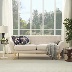 soft beige fabric sofa with rounded arms, buttoned back cushions and slim wooden legs — angled view showing the full shape...