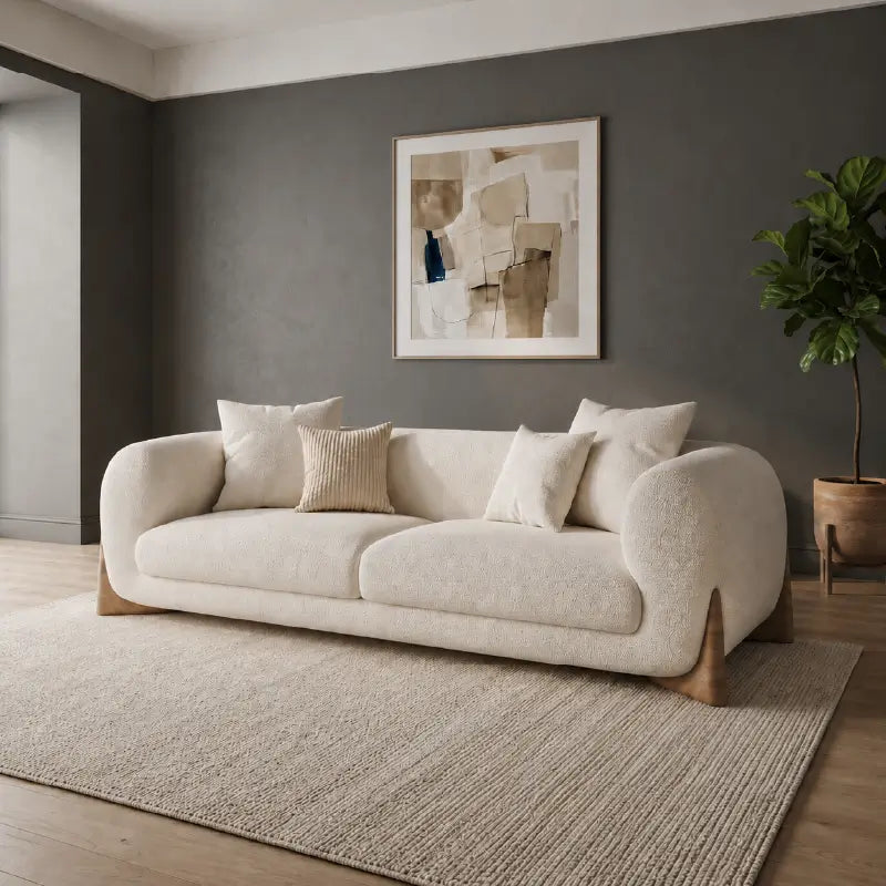 Modern living room with a gray sofa, round marble coffee table, and decorative elements.