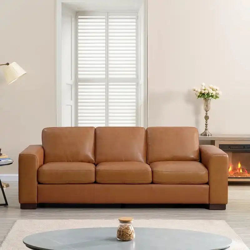 easy clean faux leather sofa with wide straight arms and thick supportive cushions — angled view showing the full shape an...