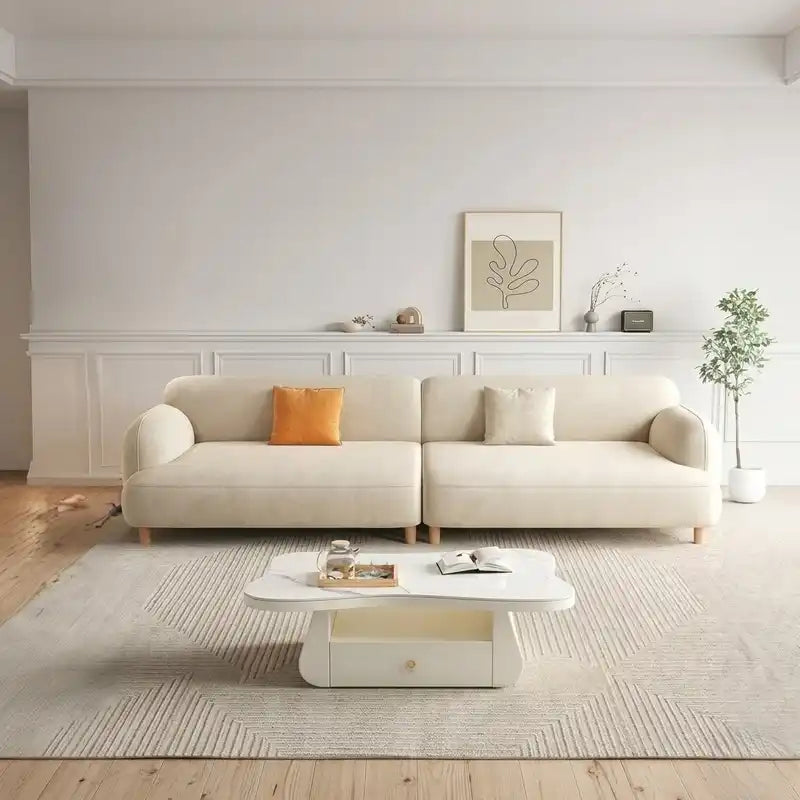 rounded fabric sofa with deep cushions, soft wide arms and a clean modern finish — angled view showing the full shape and...