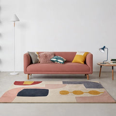 curved fabric sofa with soft wraparound arms, deep cushioning and raised wooden legs — angled view showing the full shape...