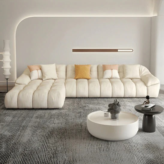 cream l shape sofa with deep soft cushions, rounded arms and a cosy low base — angled view showing the full shape and cush...