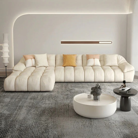 cream l shape sofa with deep soft cushions, rounded arms and a cosy low base — angled view showing the full shape and cush...