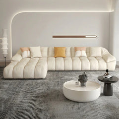cream l shape sofa with deep soft cushions, rounded arms and a cosy low base — angled view showing the full shape and cush...
