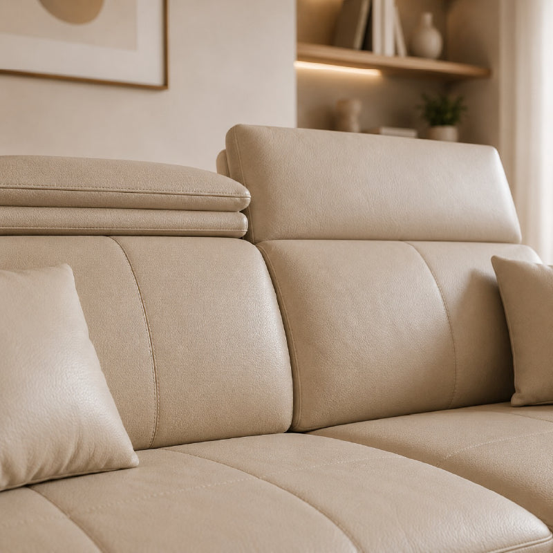 beige l shape sofa with adjustable head support, rounded arms and slim raised legs — alternate angle showing the full dept...