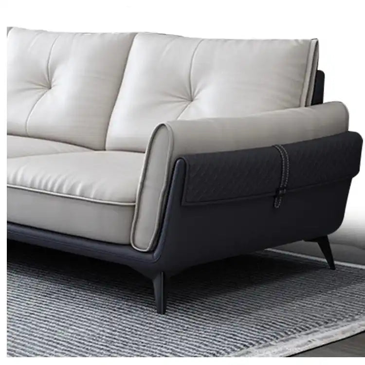 dual tone beige and charcoal fabric sofa with a soft cushioned back and deep seating — side angle showing the arms and rai...