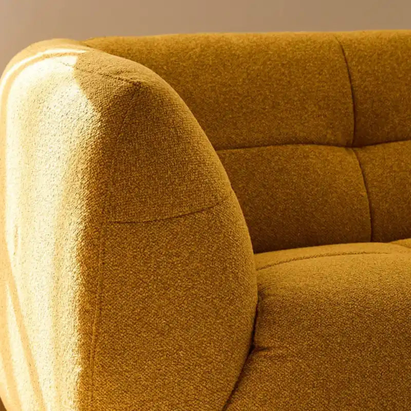 warm mustard rounded sofa with deep square cushioning and a soft textured finish — side angle showing the arms and raised...