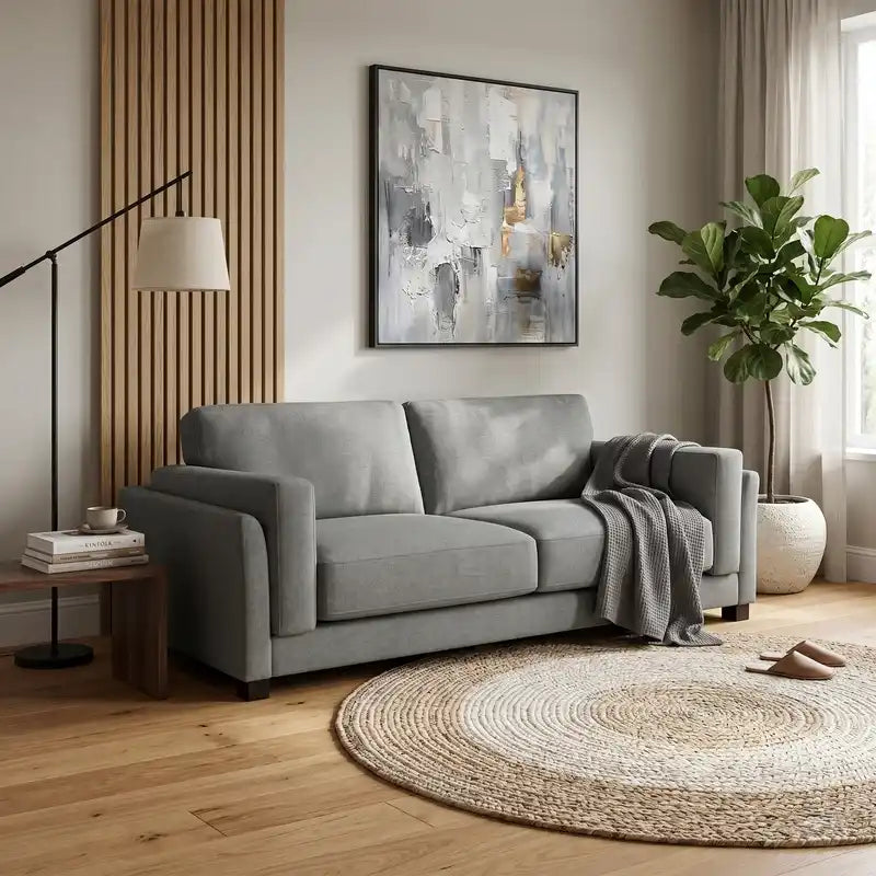 modern neutral fabric sofa with wide padded arms, thick cushions and clean straight lines — side angle showing the arms an...