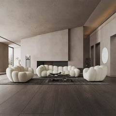 soft curved sofa with rounded cushion sections, a cloud like shape and a low relaxed base — side angle showing the arms an...