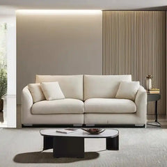 wide l shape fabric sofa with rounded arms, loose back cushions and deep comfortable seating — side angle showing the arms...
